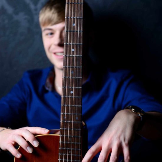 Der Gitarrist und Beatboxer Frank Schlüter sitzt hinter seiner Akustik-Gitarre