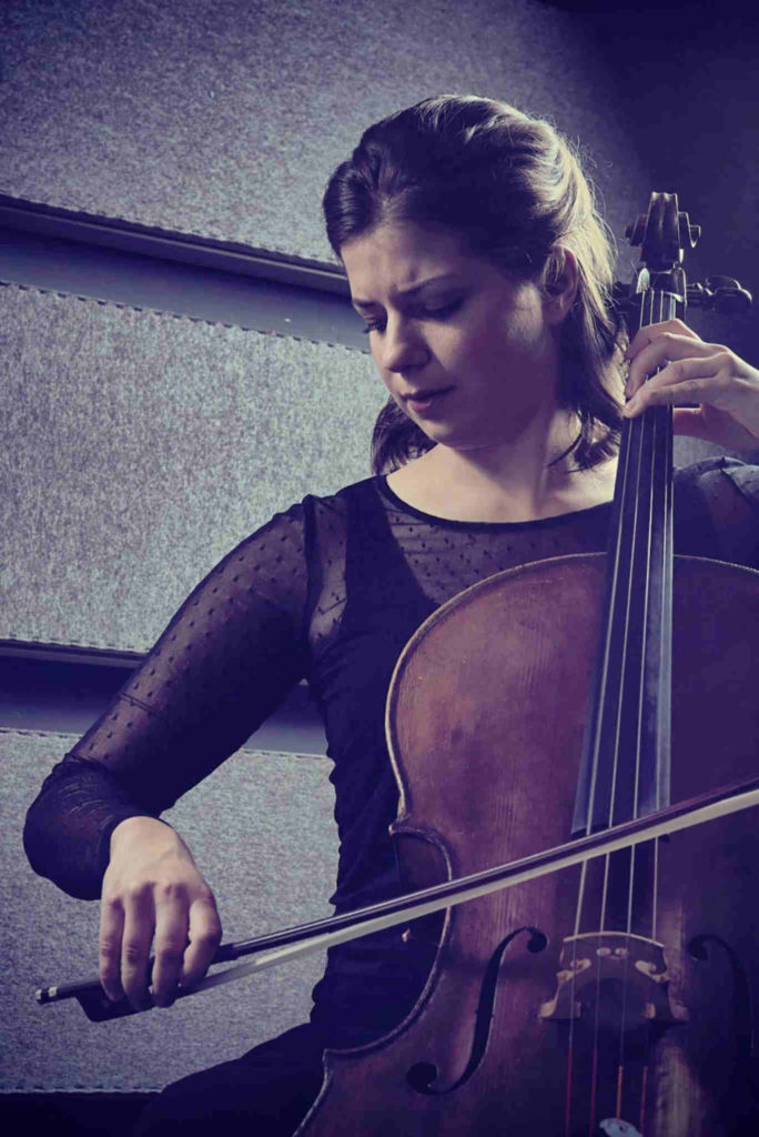 Die Cellistin Sofia von Freydorf spielt in einem schwarzen Kleid auf ihrem Cello