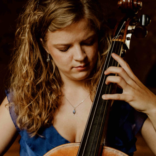 Die Musikerin Alma Stolte spielt auf ihrem Cello in einem blauen Kleid