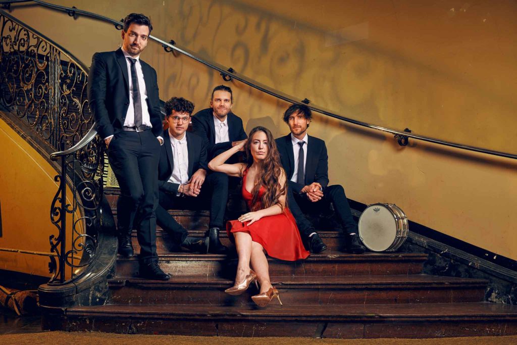 Chansons mit der Band DÉJÀ VU sitzt in einem alten Treppenhaus