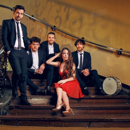 Chansons mit der Band DÉJÀ VU sitzt in einem alten Treppenhaus
