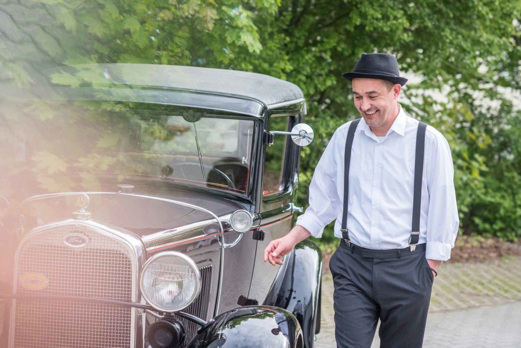 Der DJ für Ihre Firmenfeier noir.man läuft an einem Auto entlang