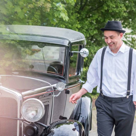Der DJ für Ihre Firmenfeier noir.man läuft an einem Auto entlang