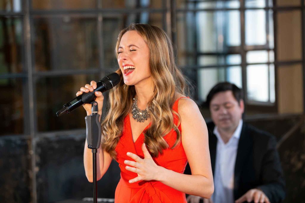 Die Sängerin Jasmin Graff singt energiegeladen in ein Mikrofon