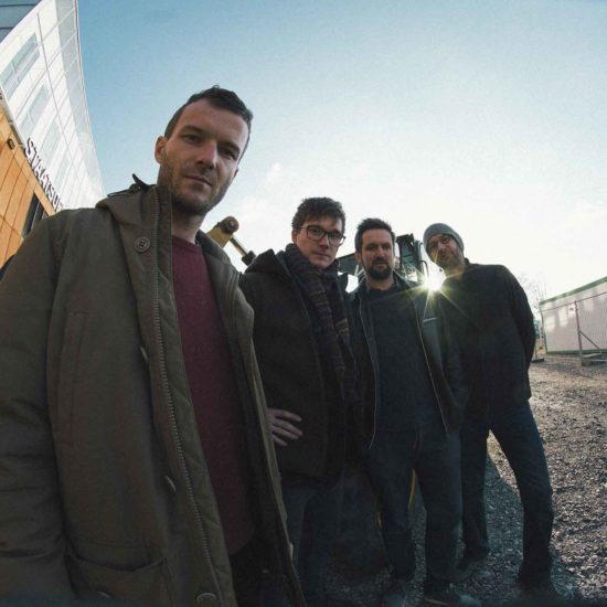 Das Richard Ebert Quartett steht auf einer Baustelle und schaut in die Kamera