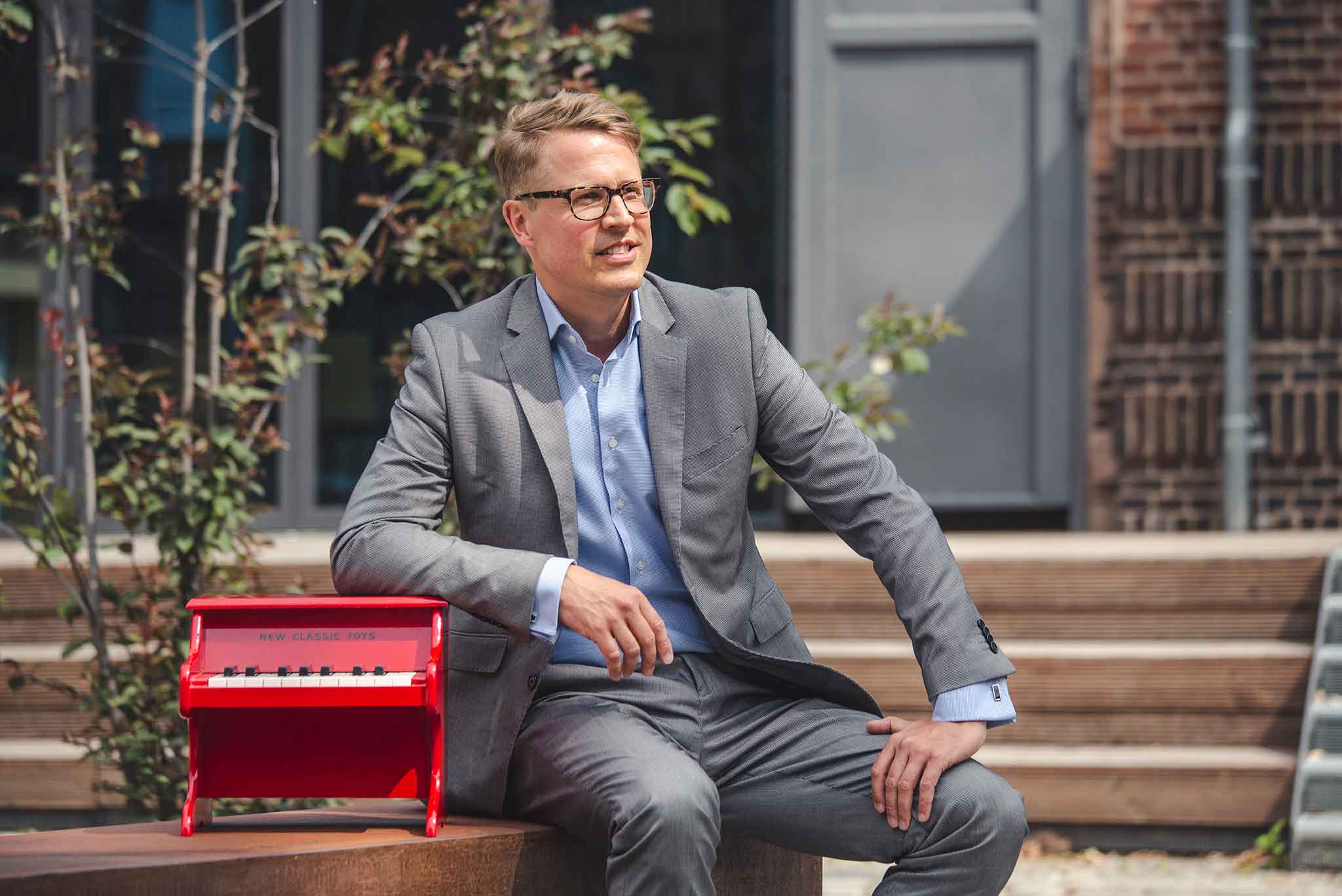 Der PIanist Moritz Töpfer sitzt un d stützt sich auf seinem Klavier auf.