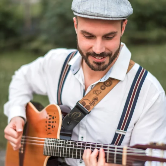 Der Gitarrenspieler Gianluca Calivà hält seine Gitarre in den Händen.