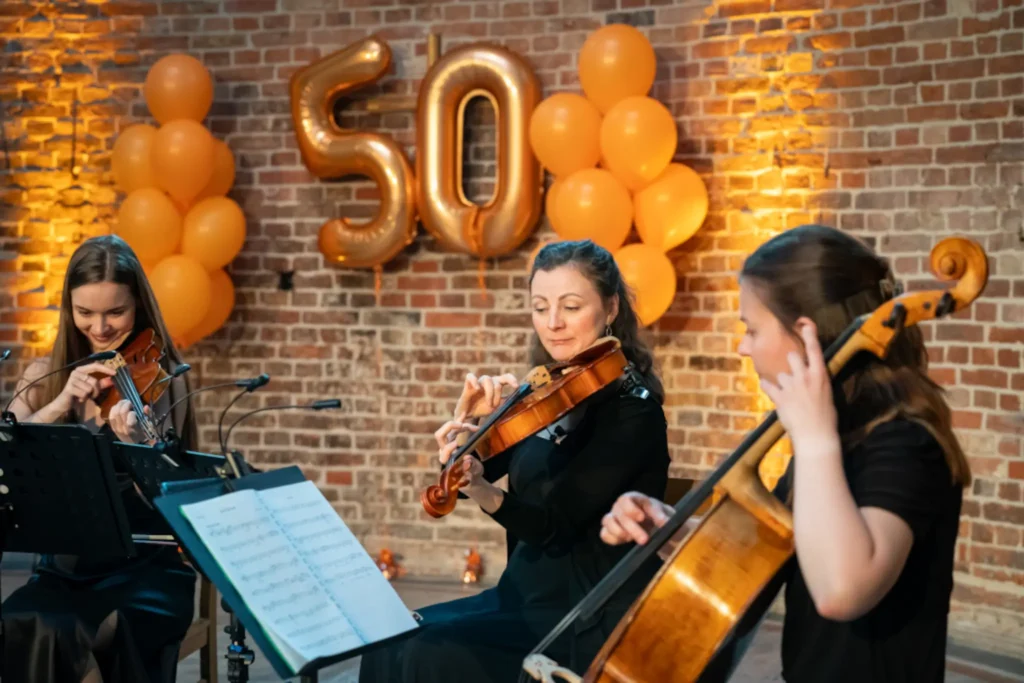 Ein Streichtrio spielt auf einer Geburtstagsfeier klassische Musik.