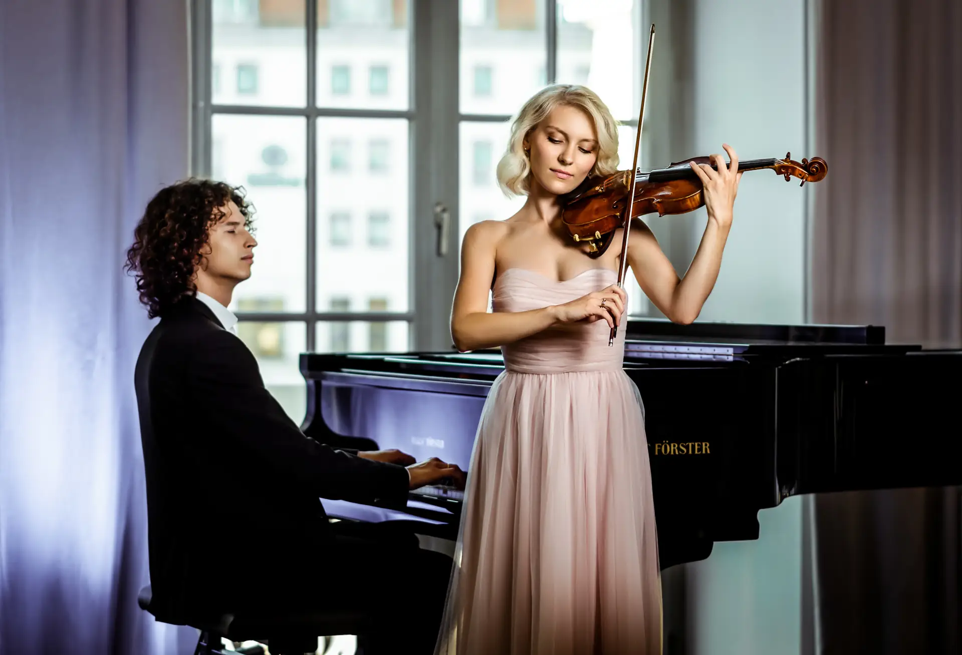 Professionelles klassisches Duo aus Violinistin und Pianist in festlicher Kleidung für Konzert- und Eventauftritte
