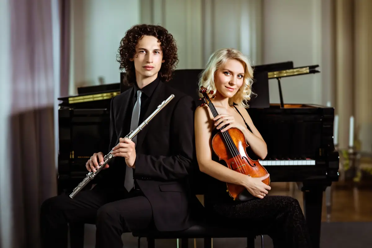 Zwei klassische Musiker mit Violine und Querflöte posieren stilvoll für ein hochwertiges Künstlerportrait